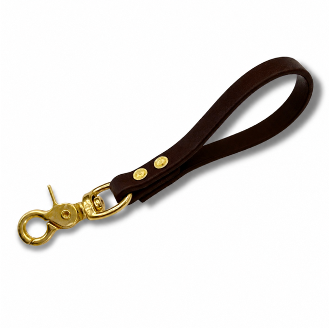 Brown Biothane dog training pull tab with solid brass snap hardware for obedience training, recall work, and off-leash dog control. Durable waterproof K9 training tab designed with heavy-duty rivets and comfortable grip for professional dog trainers, behavior correction, and everyday dog handling.